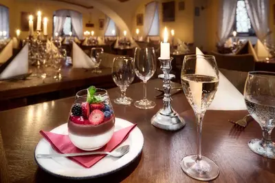 a table with a dessert and glasses of wine at Chateau Loucen Garden Retreat in Loučeň