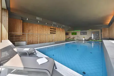 a large indoor swimming pool with chairs around it at Chateau Loucen Garden Retreat in Loučeň