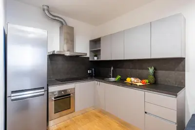 a kitchen with white cabinets and a stainless steel refrigerator at Spacious 3-bedrooms apartment near Karlin Square in Prague