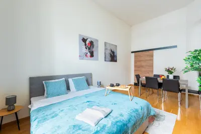 a bedroom with a large bed and a dining room at Spacious 3-bedrooms apartment near Karlin Square in Prague
