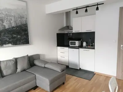 a living room with a couch and a kitchen at Brand new studio apartment # 45 with free parking in the city center in Prague