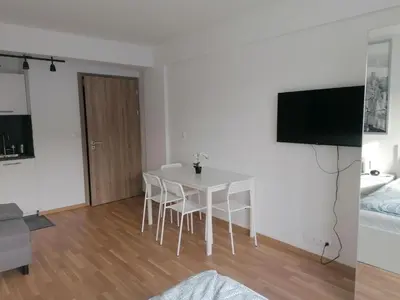 a living room with a white table and a television at Brand new studio apartment # 45 with free parking in the city center in Prague