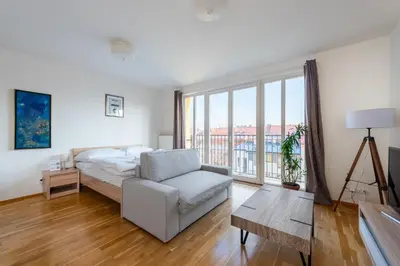 a living room with a bed and a couch at Sunny Safron apartment in Prague