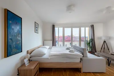 a bedroom with a large bed and a large window at Sunny Safron apartment in Prague
