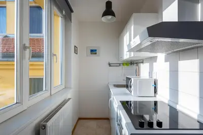 a kitchen with white appliances and a window at Sunny Safron apartment in Prague