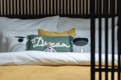 a bed with white sheets and pillows with the word dean at Prague Bohemian Rhapsody Suites in Prague