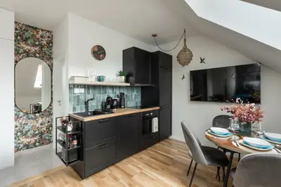 a kitchen with black cabinets and a table with chairs at Prague Bohemian Rhapsody Suites in Prague