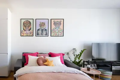 a bedroom with a bed with four pictures on the wall at Urban Chic Residences in Prague