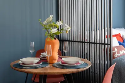 a table with two bowls and a vase with flowers at Urban Chic Residences in Prague