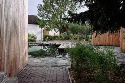 a backyard with a pond and a wooden fence at Resort po.spolu in Mokrovraty