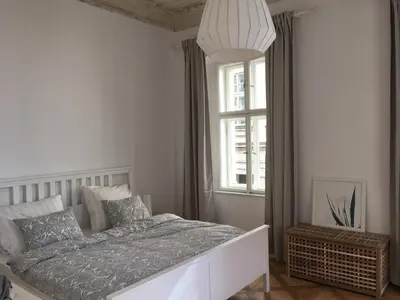 a white bedroom with a large bed and a window at Stylish apartment 5 mins from the Charles Bridge in Prague