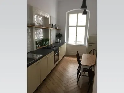 a kitchen with white cabinets and a table and a window at Stylish apartment 5 mins from the Charles Bridge in Prague