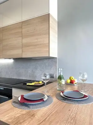 a kitchen with two plates and wine glasses on a counter at Luxury Pearl with Parking place in Holešovice in Prague