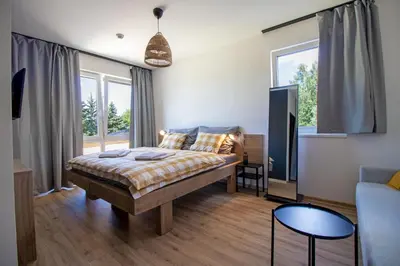 a bedroom with a bed and a couch at Penzion Racek in Tuchlovice