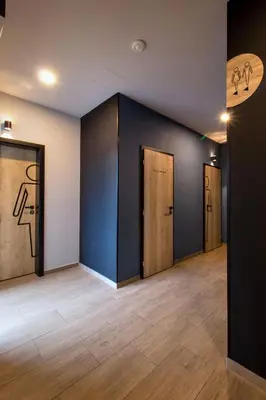 an empty room with three doors and wood floors at Penzion Racek in Tuchlovice