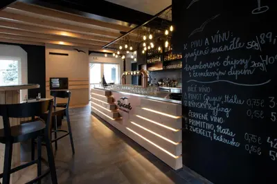a restaurant with a chalkboard wall with a bar at Penzion Racek in Tuchlovice