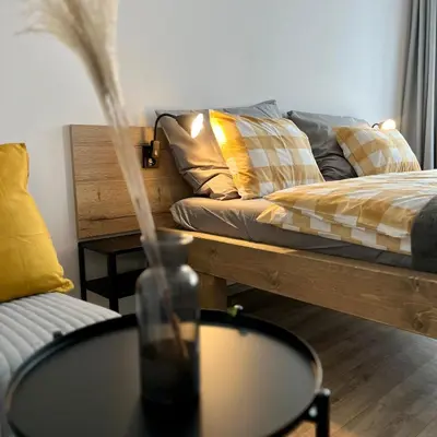 a living room with a couch and a table with a vase at Penzion Racek in Tuchlovice
