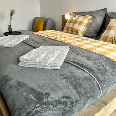 a bed with two towels on top of it at Penzion Racek in Tuchlovice