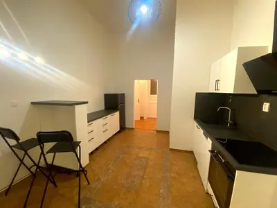 a kitchen with white cabinets and a table and chairs at Katerina's Downtown Apartments in Prague