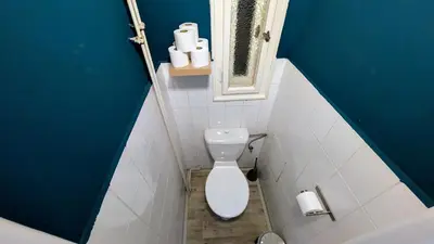 a bathroom with a toilet and a blue wall at Flat in Zizkov -403- in Prague