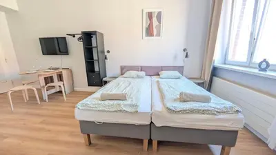 two beds in a room with a table and a tv at Flat in Zizkov -403- in Prague