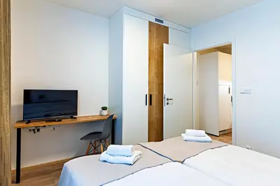a bedroom with a bed and a desk with a television at MamaStay Andel Apartments in Prague