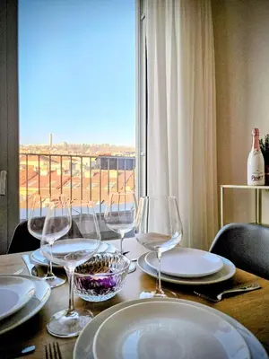 a table with glasses and plates on a table with a window at MamaStay Andel Apartments in Prague