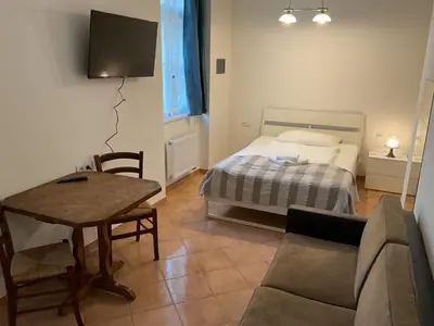 a living room with a bed and a couch and a table at Residence Ai Due Mondi in Prague