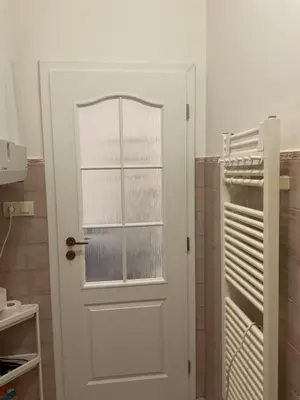 a white door with a window in a bathroom at Residence Ai Due Mondi in Prague