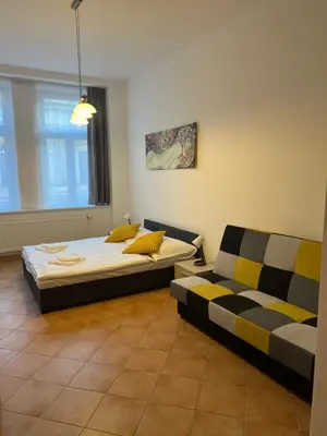 a bedroom with two beds and a couch at Residence Ai Due Mondi in Prague