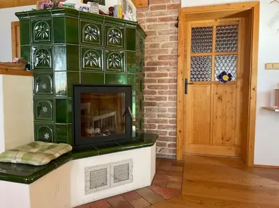 a fireplace in a living room with a brick wall at Roubenka v Posázaví in Zbizuby