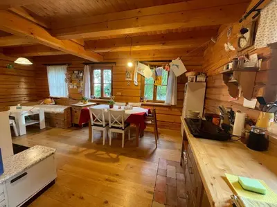 a kitchen and dining room with a table in a cabin at Roubenka v Posázaví in Zbizuby