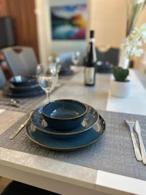 a table with blue plates and a glass on it at O2 Aréna -PVA expo - Tomy Apartment -Praha in Prague