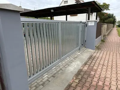 a gate on the side of a house with a brick driveway at O2 Aréna -PVA expo - Tomy Apartment -Praha in Prague