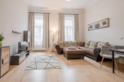 a living room with a couch and a tv at Palace Petrarca in Prague