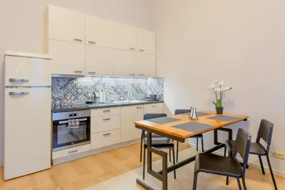 a kitchen with a wooden table and a refrigerator at Palace Petrarca in Prague
