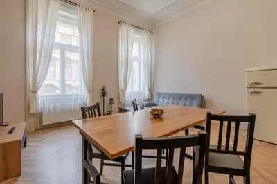a kitchen and dining room with a wooden table and chairs at Palace Petrarca in Prague