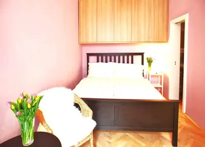 a bedroom with a bed and a vase of flowers on a table at Lovely Lila apartment in Prague