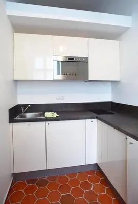 a kitchen with white cabinets and a sink at Lovely Lila apartment in Prague