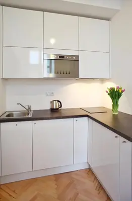 a kitchen with white cabinets and a sink at Lovely Lila apartment in Prague