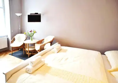 a bedroom with a bed and a table with chairs at Grey cozy apartment in Prague