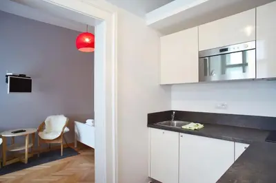a kitchen with white cabinets and a red light at Grey cozy apartment in Prague
