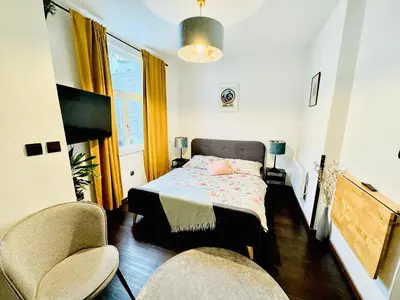 a bedroom with a bed and two chairs at Apartments by Jacob in Prague