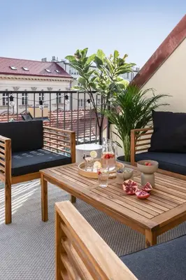 a balcony with two tables and chairs and lights at TurnKey I Republic Square Apartments in Prague