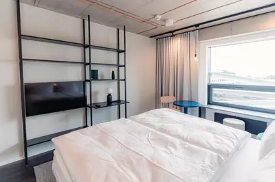 a bedroom with a bed and a large window at HONEST Ricany in Ricany