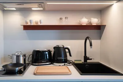 a kitchen counter with a sink and a coffee maker at HONEST Ricany in Ricany