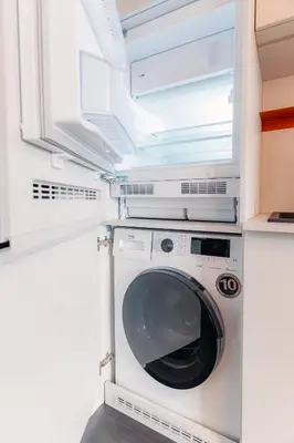 a washing machine in a kitchen with a window at HONEST Ricany in Ricany