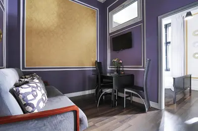 a bedroom with purple walls and a table and a tv at Two-bedroom Haven In The Old Town in Prague