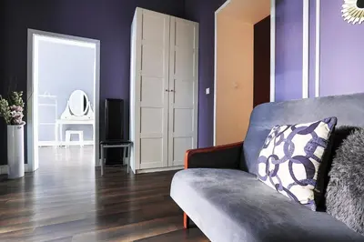 a living room with purple walls and a couch at Two-bedroom Haven In The Old Town in Prague