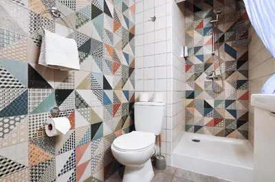 a bathroom with a toilet and a mosaic wall at Two-bedroom Haven In The Old Town in Prague